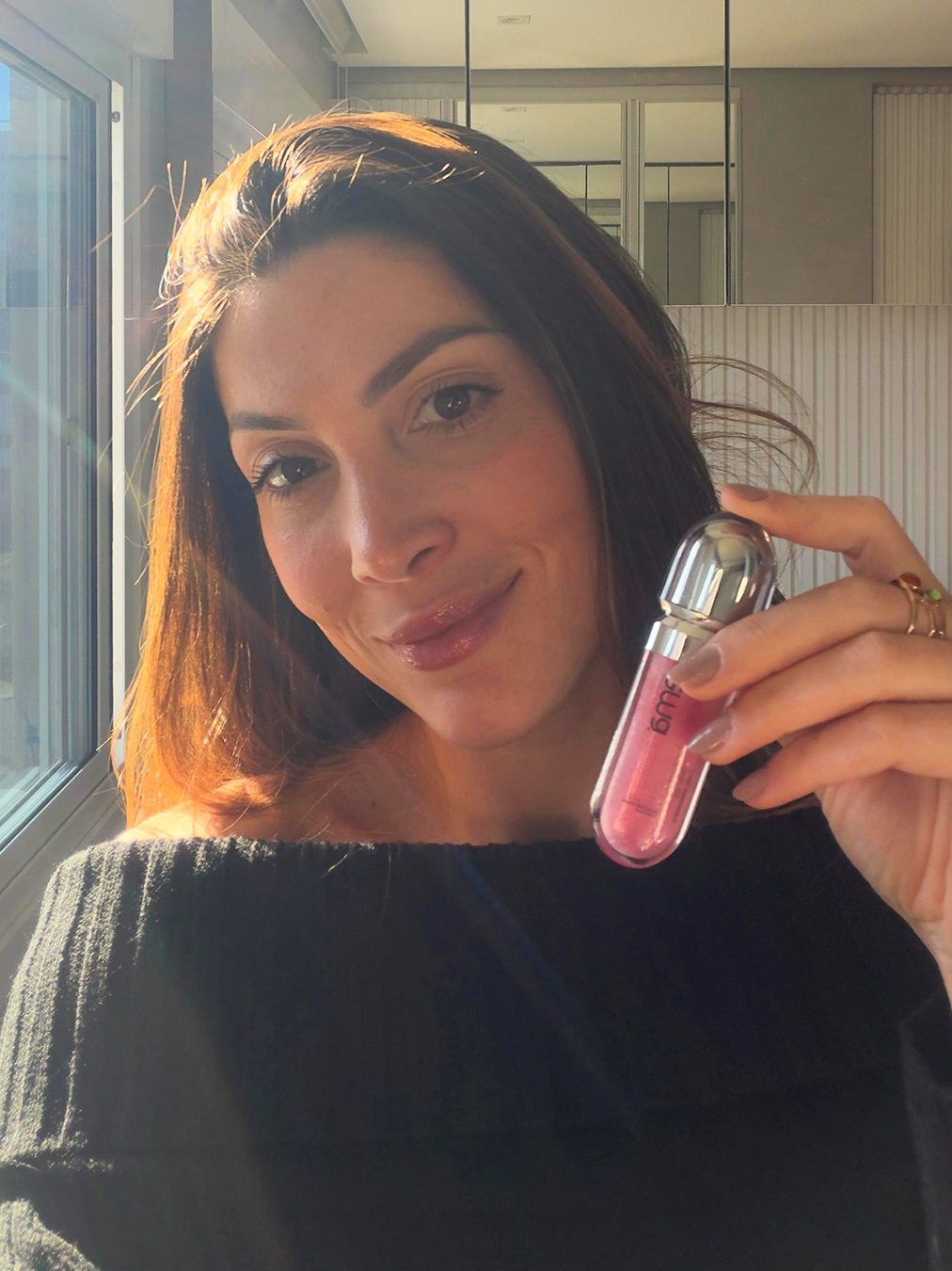 Júlia de Cesaro segurando um gloss labial